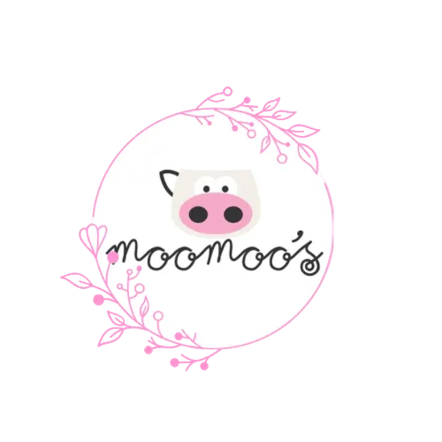 A circular logo on a light pink background featuring a cartoon cow face with a pink nose and black eyes, surrounded by pink floral branches. The script text reads 'moomoo's'.