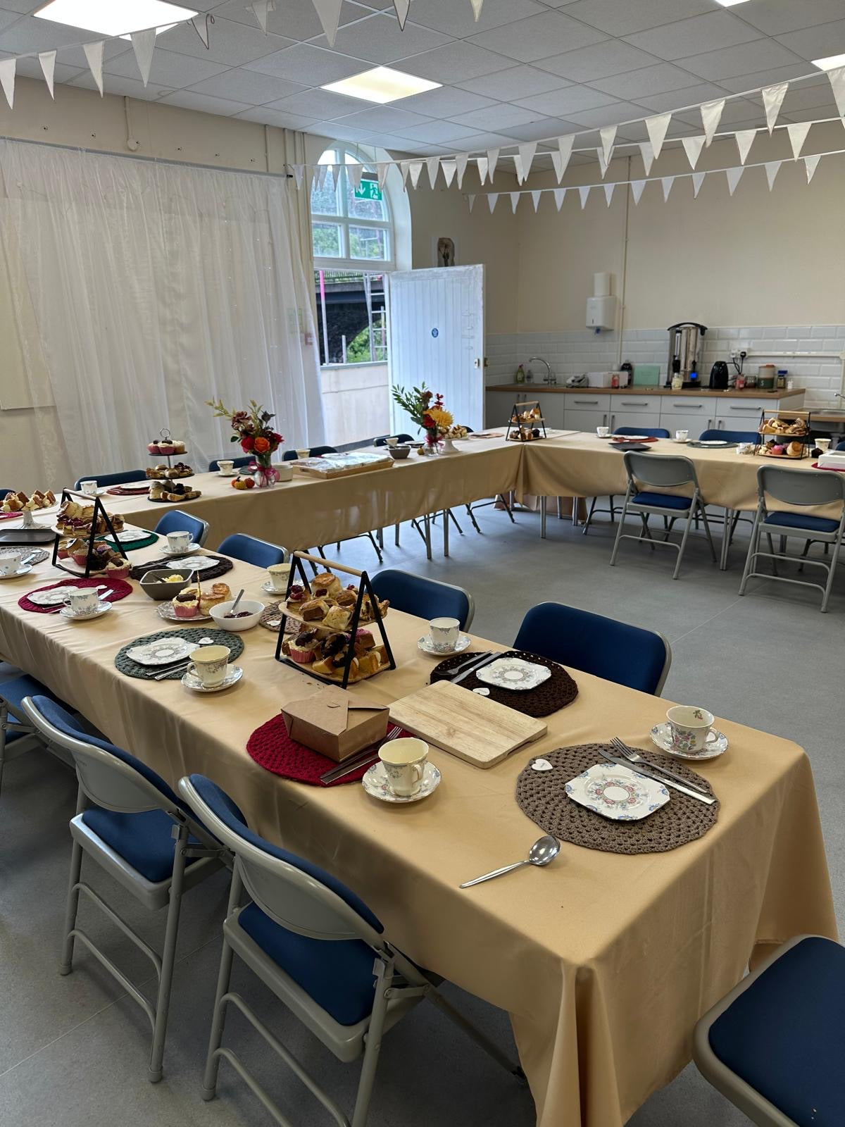 Dining hall with tables set for a meal, chairs, and decorations.